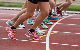 Runners lined up at a starting line for a track race